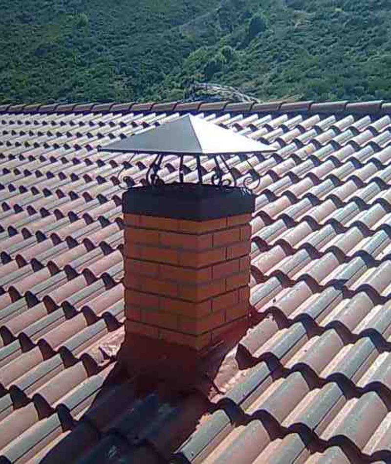 Capota de chimenea en ladrillo visto y forja.