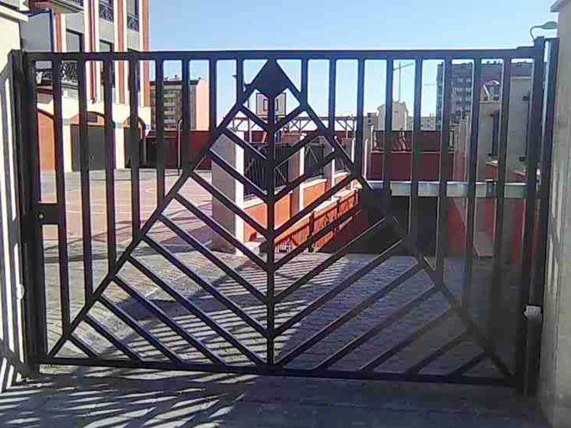 Puerta de forja con barrotes en la entrada del garaje un edificio.